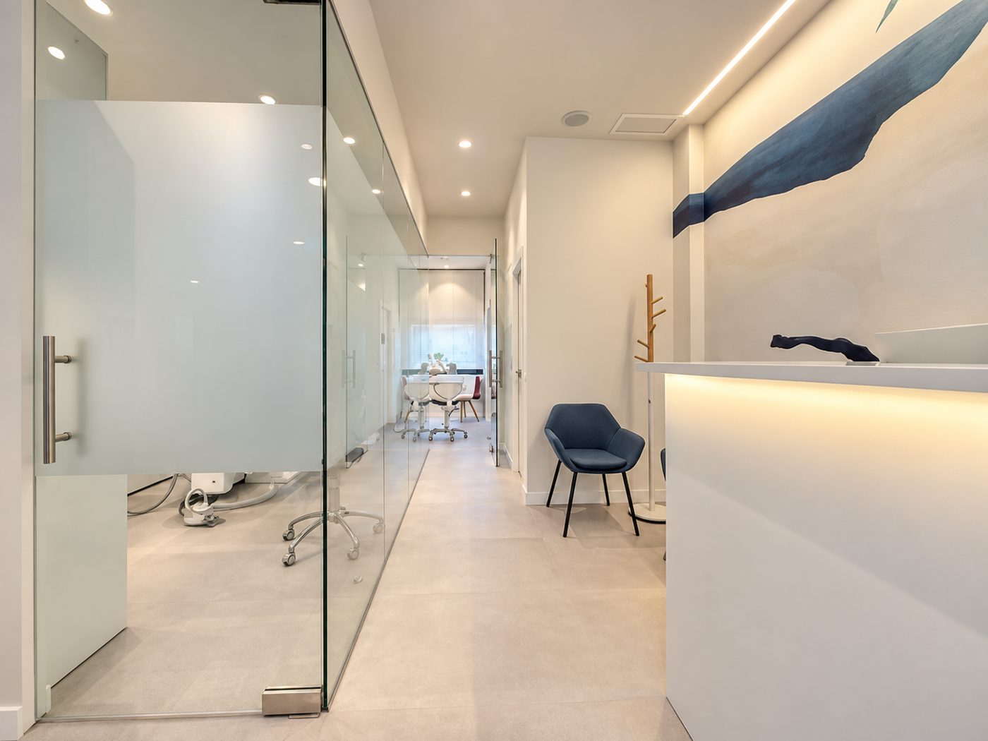 Pasillo con mamparas de cristal y recepción